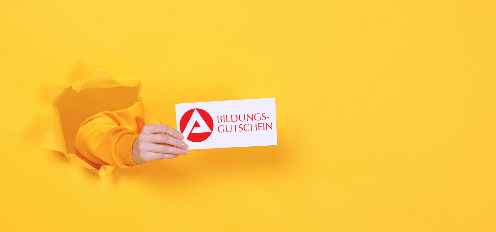 Eine Hand reicht den Bildungsgutschein